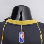 camiseta raptors negra y dorada cuello anterior y logo nba